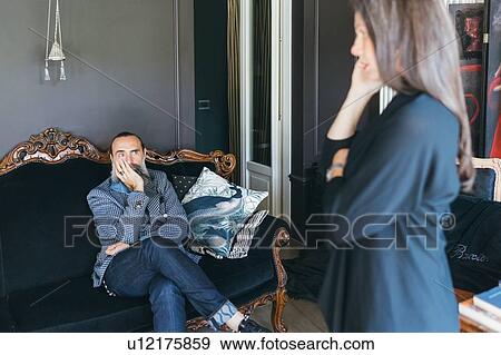 Couple discussing problem in living room View Large Photo Image Stock Photo - Couple discussing problem in living room. Fotosearch