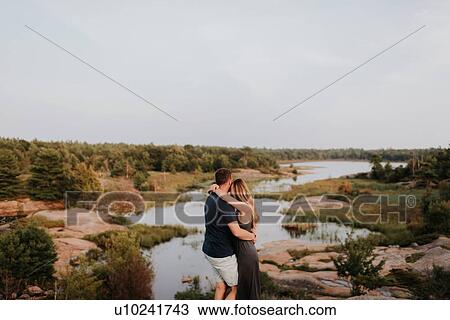 Stock Image - Couple enjoying view of river, Algonquin Park, Canada. Fotosearch