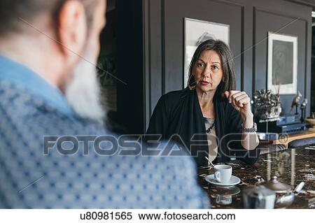 Stock Photography - Couple in discussion over coffee in kitchen. Fotosearch