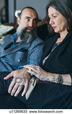 Stock Image - Couple on sofa looking worried. Fotosearch