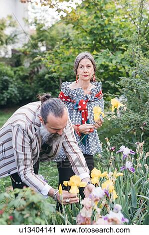 Stock Image - Couple picking flowers from garden. Fotosearch