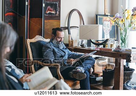 Stock Image - Couple reading in room. Fotosearch