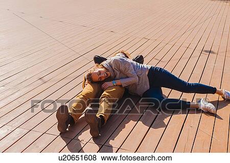Couple relaxing on wooden decking View Large Photo Image Stock Photo - Couple relaxing on wooden decking. Fotosearch