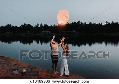 Couple releasing sky lanterns by lake, Algonquin Park, Canada View Large Photo Image Stock Photograph - Couple releasing sky lanterns by lake, Algonquin Park, Canada. Fotosearch