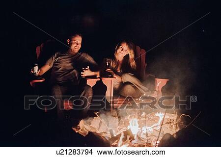 Picture - Couple sitting by camp fire, Algonquin Park, Canada. Fotosearch