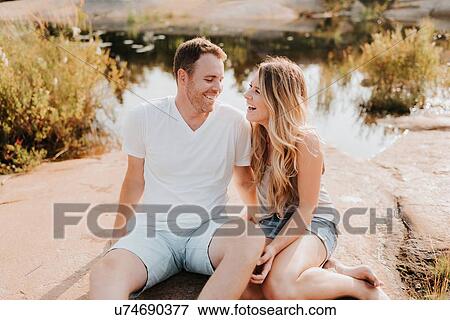 Couple sitting by water, Algonquin Park, Canada View Large Photo Image Stock Photo - Couple sitting by water, Algonquin Park, Canada. Fotosearch