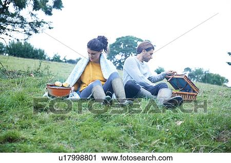 Couple sitting in rural field cooking on barbecue grill View Large Photo Image Stock Image - Couple sitting in rural field cooking on barbecue grill. Fotosearch