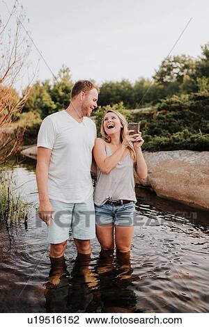 Stock Image - Couple taking selfie in water, Algonquin Park, Canada. Fotosearch