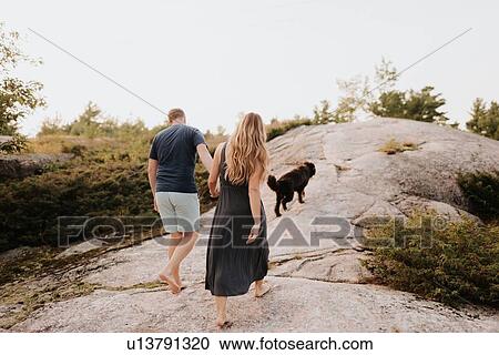 Stock Image - Couple walking with pet dog, Algonquin Park, Canada. Fotosearch