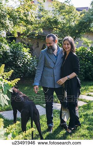 Stock Photograph - Couple with pet dog in garden. Fotosearch