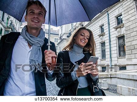 Picture - Couple with umbrella on morning commute, Budapest, Hungary. Fotosearch