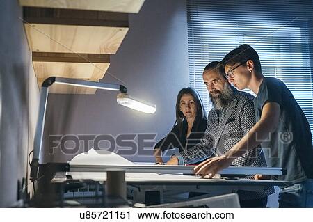 Stock Image - Couple working with son in home office. Fotosearch