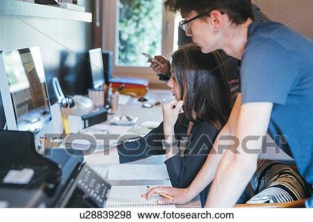 Stock Photo - Couple working with son in home office. Fotosearch