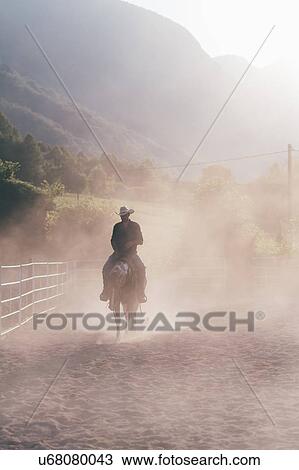 Cowboy riding horse in dusty equestrian arena, Primaluna, Trentino-Alto Adige, Italy View Large Photo Image Stock Image - Cowboy riding horse in dusty equestrian arena, Primaluna, Trentino-Alto Adige, Italy. Fotosearch