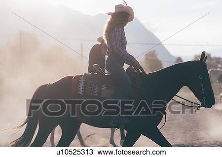 Cowgirl horse riding in dusty equestrian arena, sideview Primaluna, Trentino-Alto Adige, Italy View Large Photo Image Stock Image - Cowgirl horse riding in dusty equestrian arena, sideview Primaluna, Trentino-Alto Adige, Italy. Fotosearch