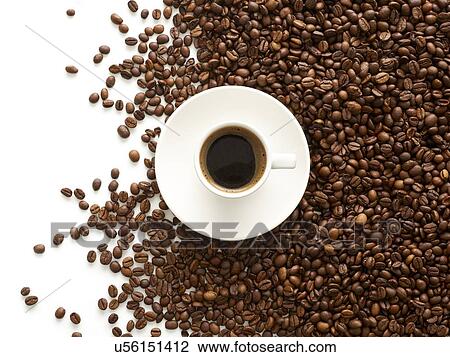 Stock Image - Cup of coffee and coffee beans, high angle view.. Fotosearch