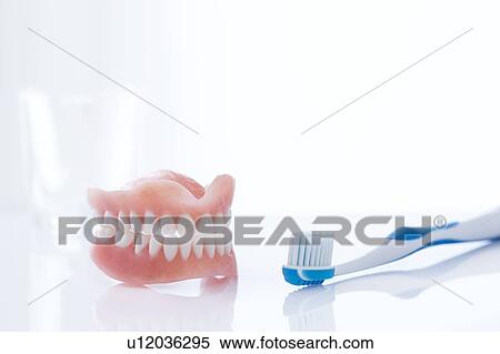 Dentures and toothbrush against a white background. View Large Photo Image Stock Photography - Dentures and toothbrush against a white background.. Fotosearch