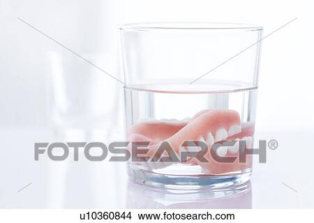 Dentures in a glass of water. View Large Photo Image Picture - Dentures in a glass of water.. Fotosearch