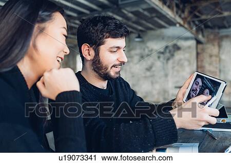Stock Image - Designer and colleague taking selfie with digital tablet. Fotosearch