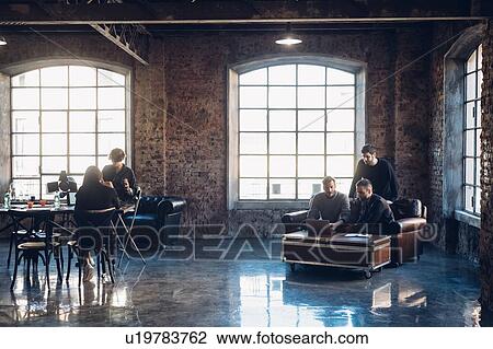 Stock Image - Designers brainstorming in communal space in studio. Fotosearch