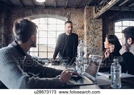 Stock Image - Designers having meeting in studio. Fotosearch