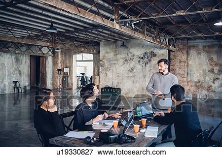 Stock Photo - Designers having meeting in studio. Fotosearch