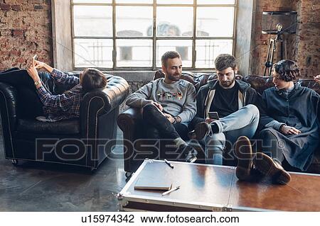 Designers taking break on sofa in studio View Large Photo Image Stock Image - Designers taking break on sofa in studio. Fotosearch