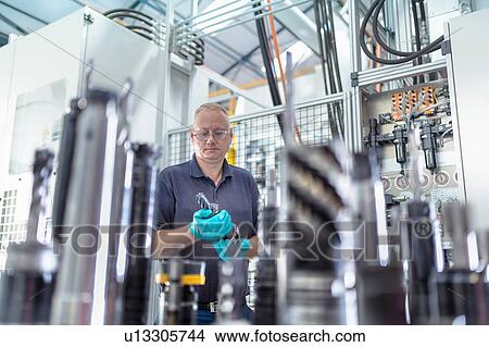 Engineer inspecting CNC cutting tools in gearbox factory View Large Photo Image Picture - Engineer inspecting CNC cutting tools in gearbox factory. Fotosearch