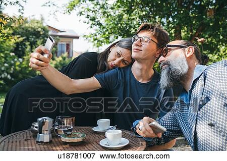 Family taking selfie over coffee in patio View Large Photo Image Stock Photo - Family taking selfie over coffee in patio. Fotosearch