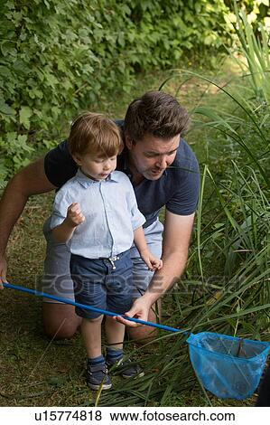 Stock Photo - Father and child looking in fishing net. Fotosearch