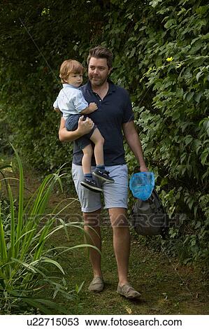 Stock Image - Father and child with fishing net in park. Fotosearch