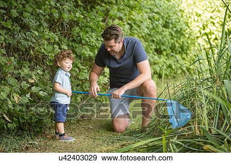 Stock Photo - Father and child with fishing net in park. Fotosearch