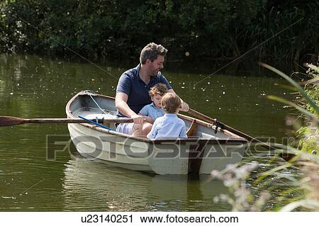 Stock Image - Father and children on boat ride in lake. Fotosearch