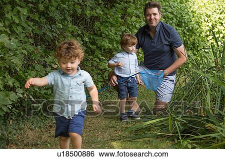 Stock Photograph - Father and children with fishing net in park. Fotosearch