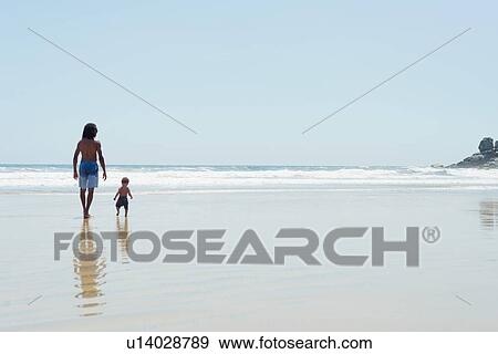 Stock Photo - Father and son walking on beach. Fotosearch