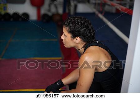 Stock Photo - Female boxer resting in gym. Fotosearch