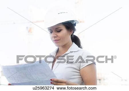 Picture - Female engineer reading blueprint. Fotosearch