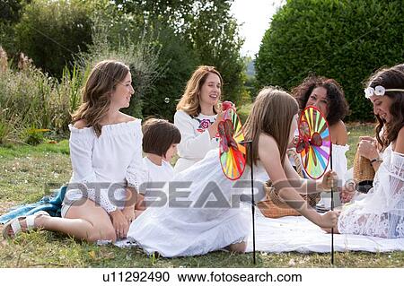 Female friends and family having picnic in garden View Large Photo Image Stock Image - Female friends and family having picnic in garden. Fotosearch