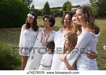 Stock Photograph - Female friends and family posing for portrait in garden. Fotosearch