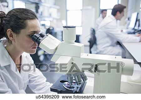 Stock Photo - Female laboratory assistant using microscope.. Fotosearch