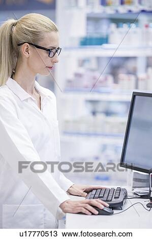 Female pharmacist working on computer in pharmacy. View Large Photo Image Stock Image - Female pharmacist working on computer in pharmacy.. Fotosearch