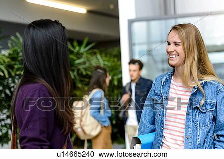Female university students chatting together in university lobby View Large Photo Image Stock Image - Female university students chatting together in university lobby. Fotosearch
