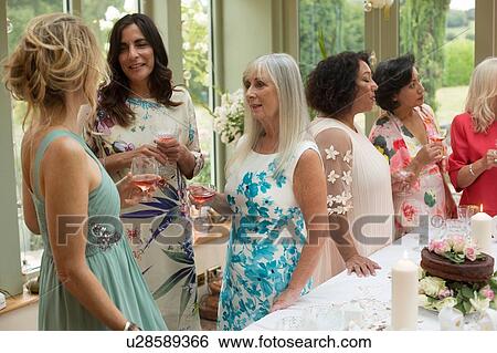 Stock Photograph - Female wedding guests at reception. Fotosearch