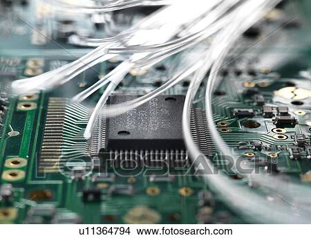 Picture - Fibre optics carrying data passing through a circuit board to illustrate artificial intelligence. Fotosearch