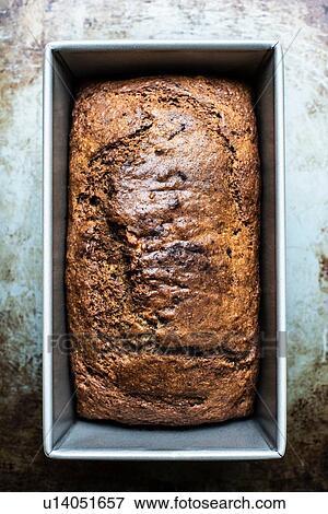 Stock Photo - Freshly baked banana bread in loaf tin. Fotosearch