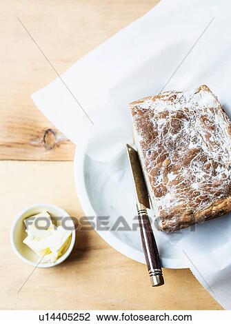 Stock Image - Freshly baked bread with butter. Fotosearch