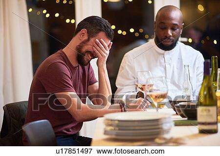 Stock Photo - Friend laughing at dinner party. Fotosearch
