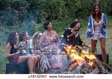 Stock Image - Friends at bonfire party in park. Fotosearch