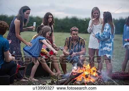 Stock Photo - Friends at bonfire party in park. Fotosearch
