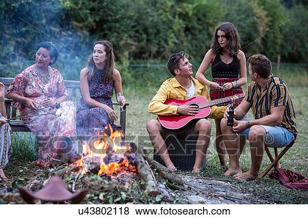 Stock Photo - Friends at bonfire party in park. Fotosearch